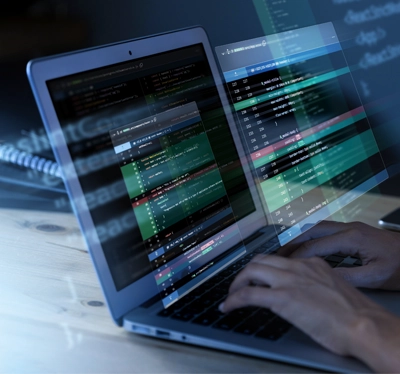 Manos programando en laptop.